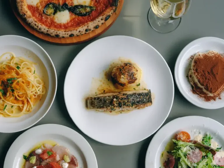 ピザやパスタ、ティラミスを卓上に並べたレストラン「TARU」の料理