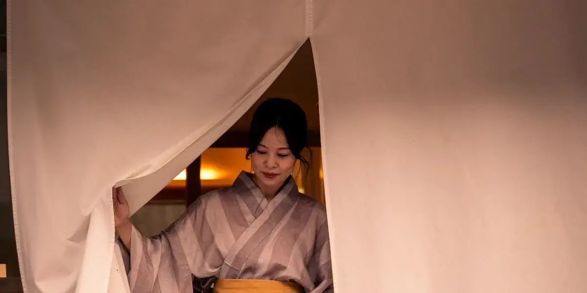 恩湯の暖簾をくぐって出てくる浴衣姿の女性