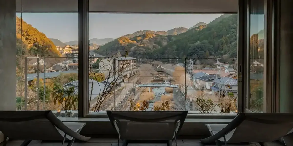 SOIL Nagatoyumoto のサウナの窓から見える山と温泉街